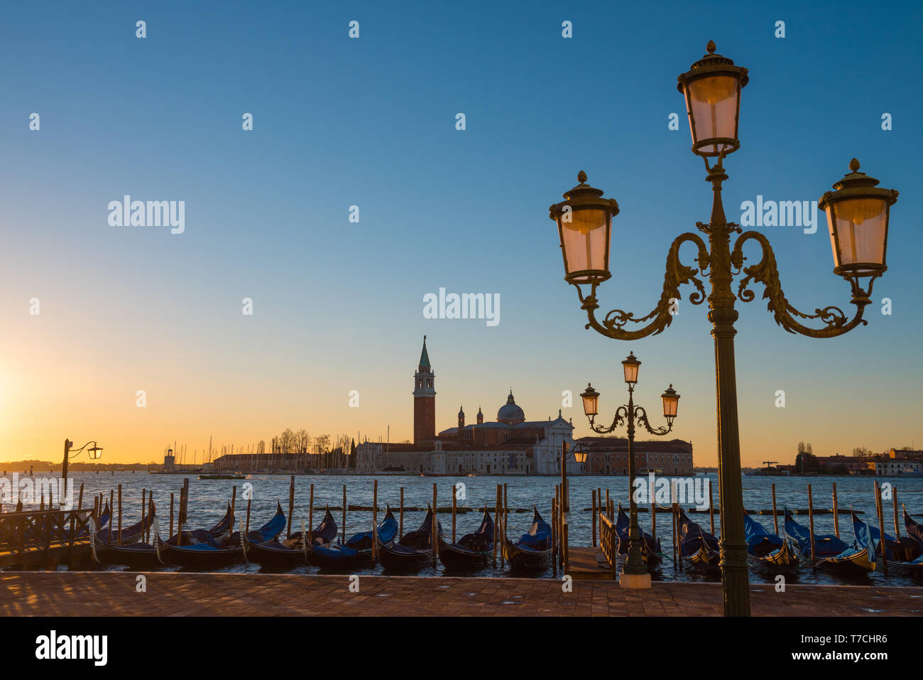 Venezia Italia lungomare con gondole e lanterne di sunrise Foto Stock