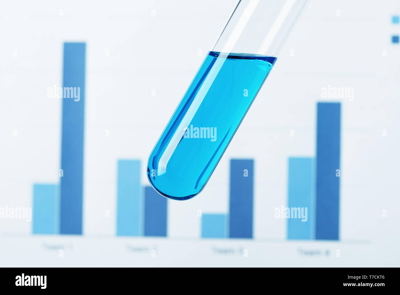 Tubo di prova con il liquido blu su analisi scientifiche grafici sullo sfondo Foto Stock
