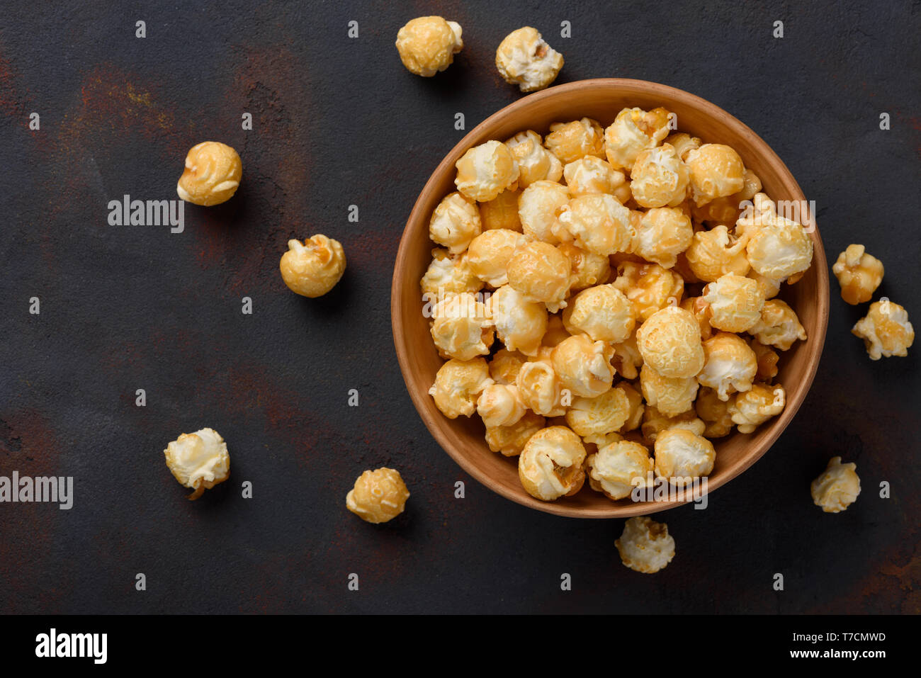 Caramello popcorn nella ciotola sul tavolo scuro dello sfondo vista superiore Foto Stock