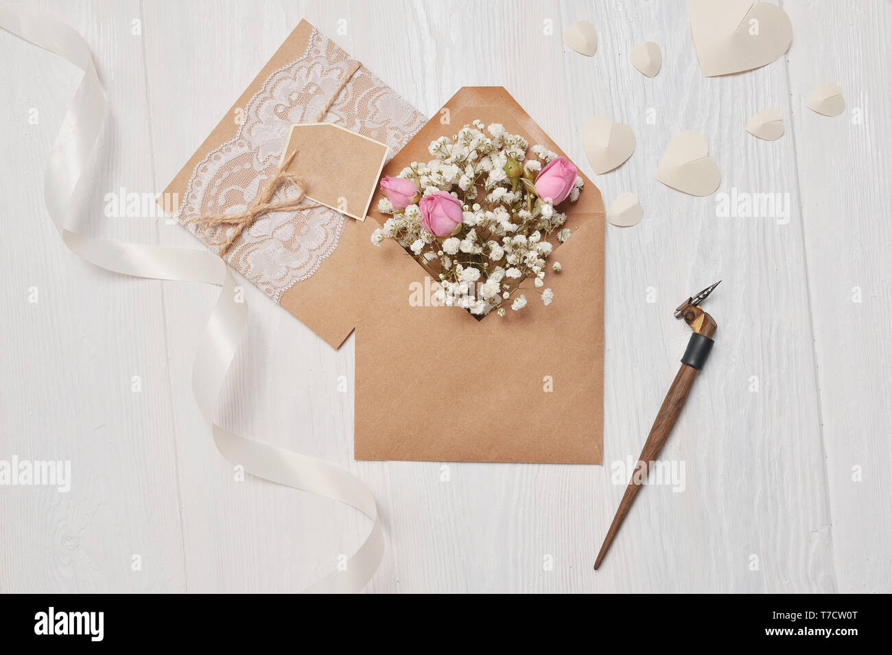Calligrafica giù una busta con fiori e una lettera, un biglietto di auguri per il giorno di San Valentino con posto per il vostro testo. Piatto, laici top view photo mock u Foto Stock