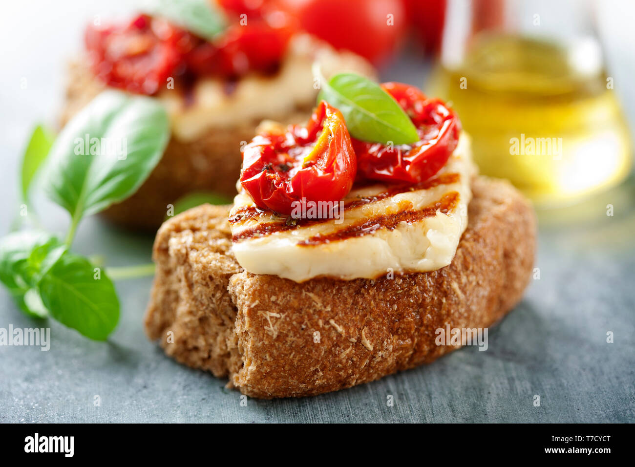 Fette biscottate integrali con haloumi e pomodoro secco Foto Stock