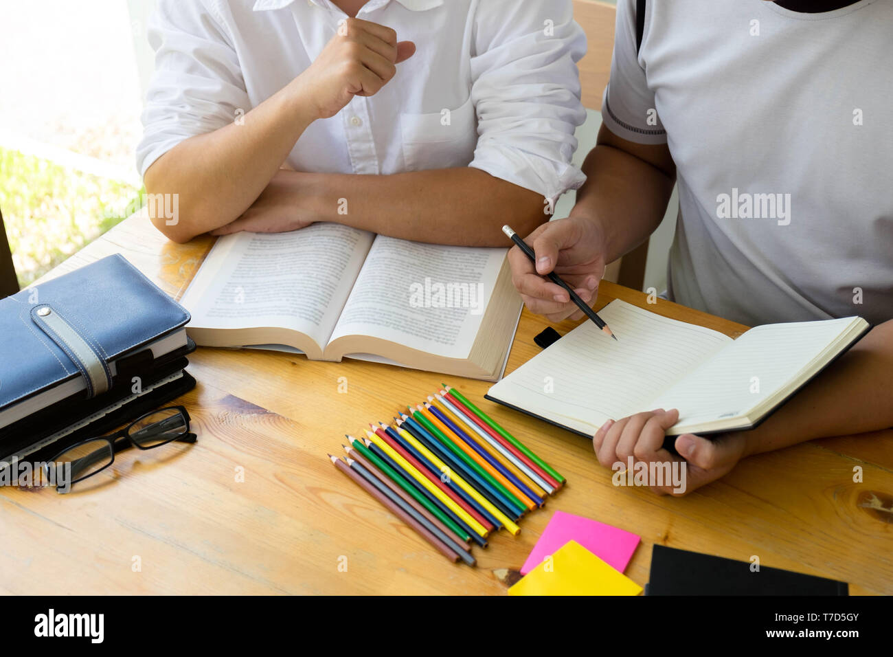 Gli studenti amico aiuta l insegnamento e l apprendimento oggetto ulteriori nella libreria. Il concetto di istruzione. Foto Stock