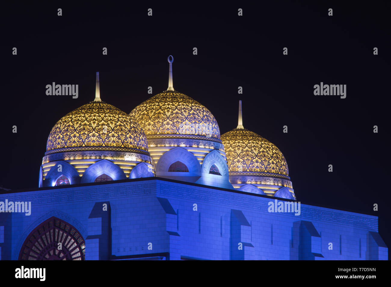 Al Ameen moschea della città incandescente di notte porpora e giallo in Muscat Oman. Foto Stock