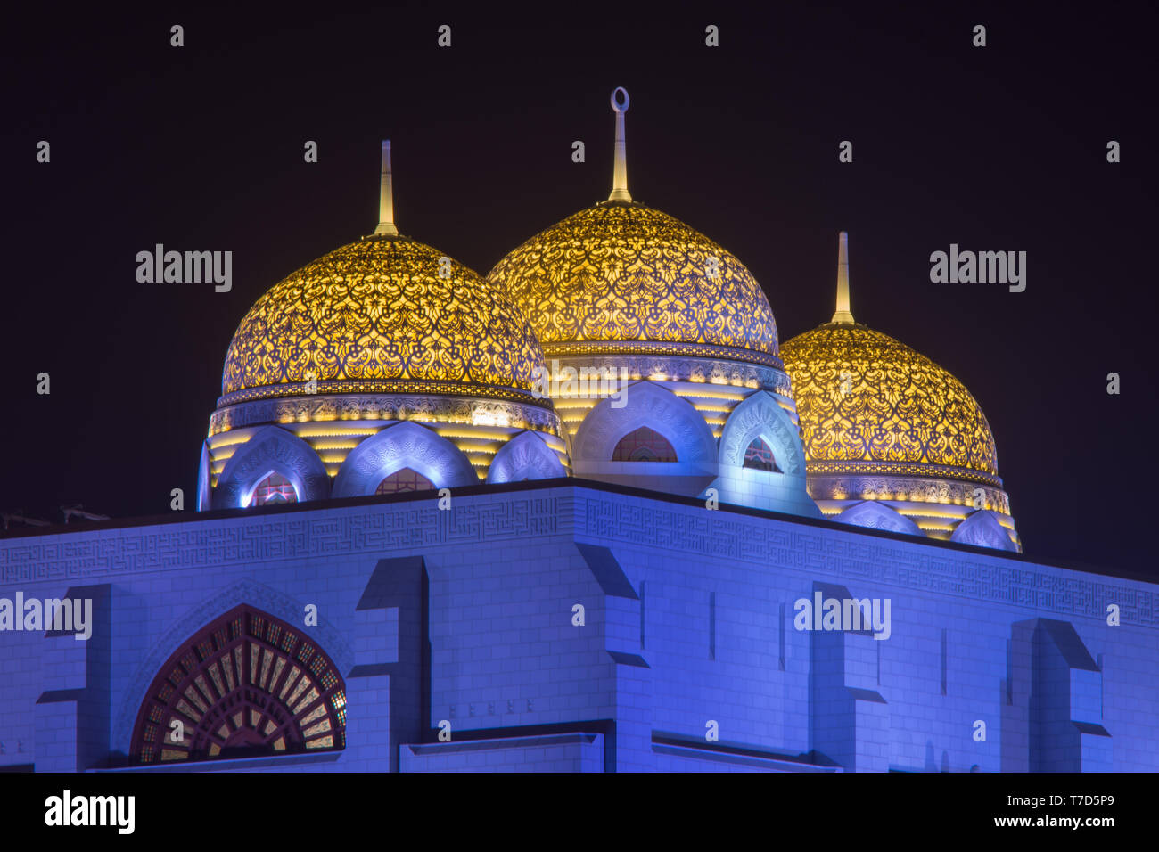Al Ameen moschea della città incandescente di notte porpora e giallo in Muscat Oman. Foto Stock
