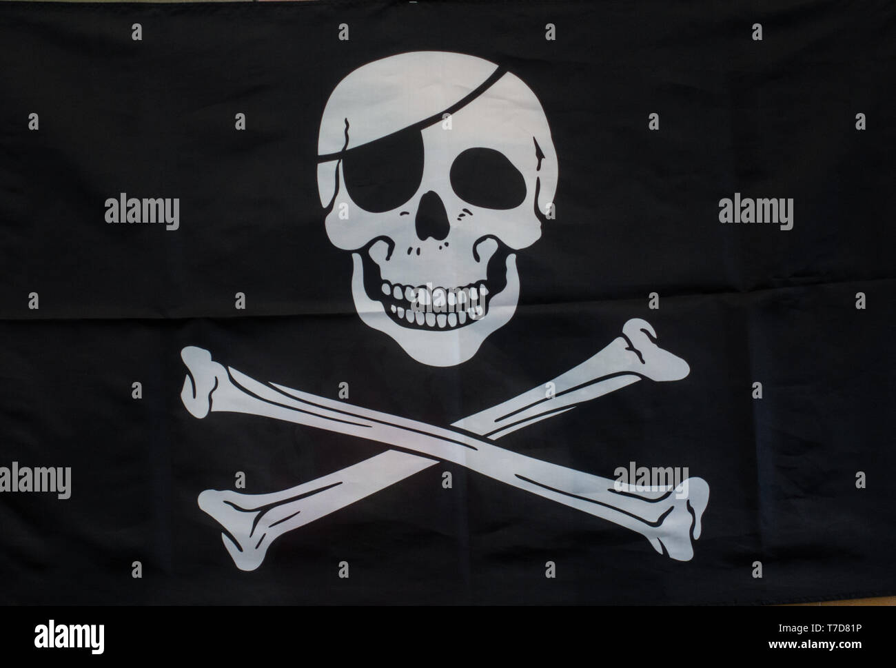 Nero bandiera pirata con teschio bianco con occhio bendato Foto Stock