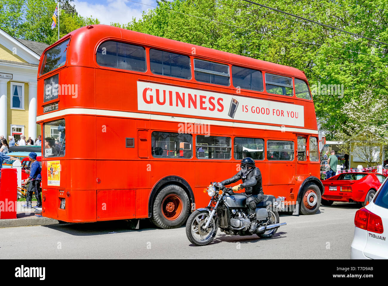 Motociclista e bus rosso a due piani con Guinness annuncio. Foto Stock