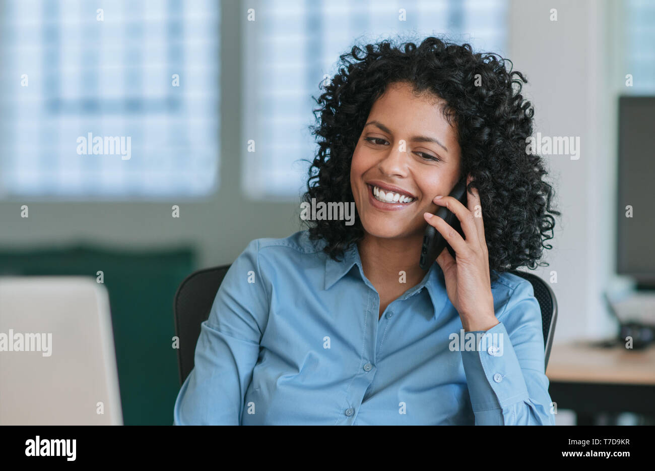 Coppia imprenditrice seduto alla sua scrivania a parlare su un telefono cellulare Foto Stock