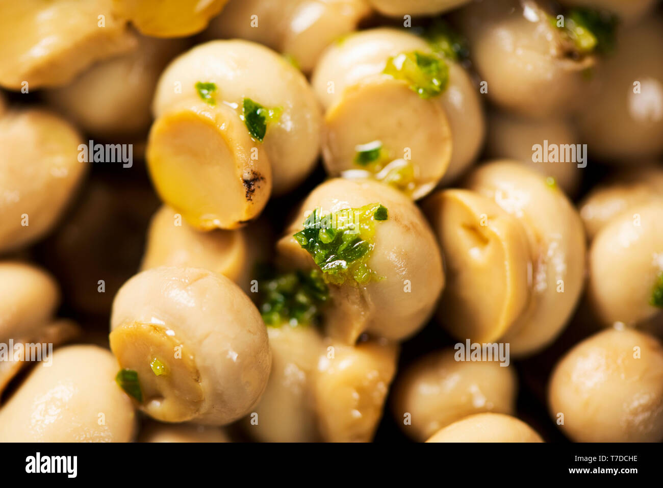 Primo piano di alcuni mini funghi comuni cotte con aglio e prezzemolo Foto Stock