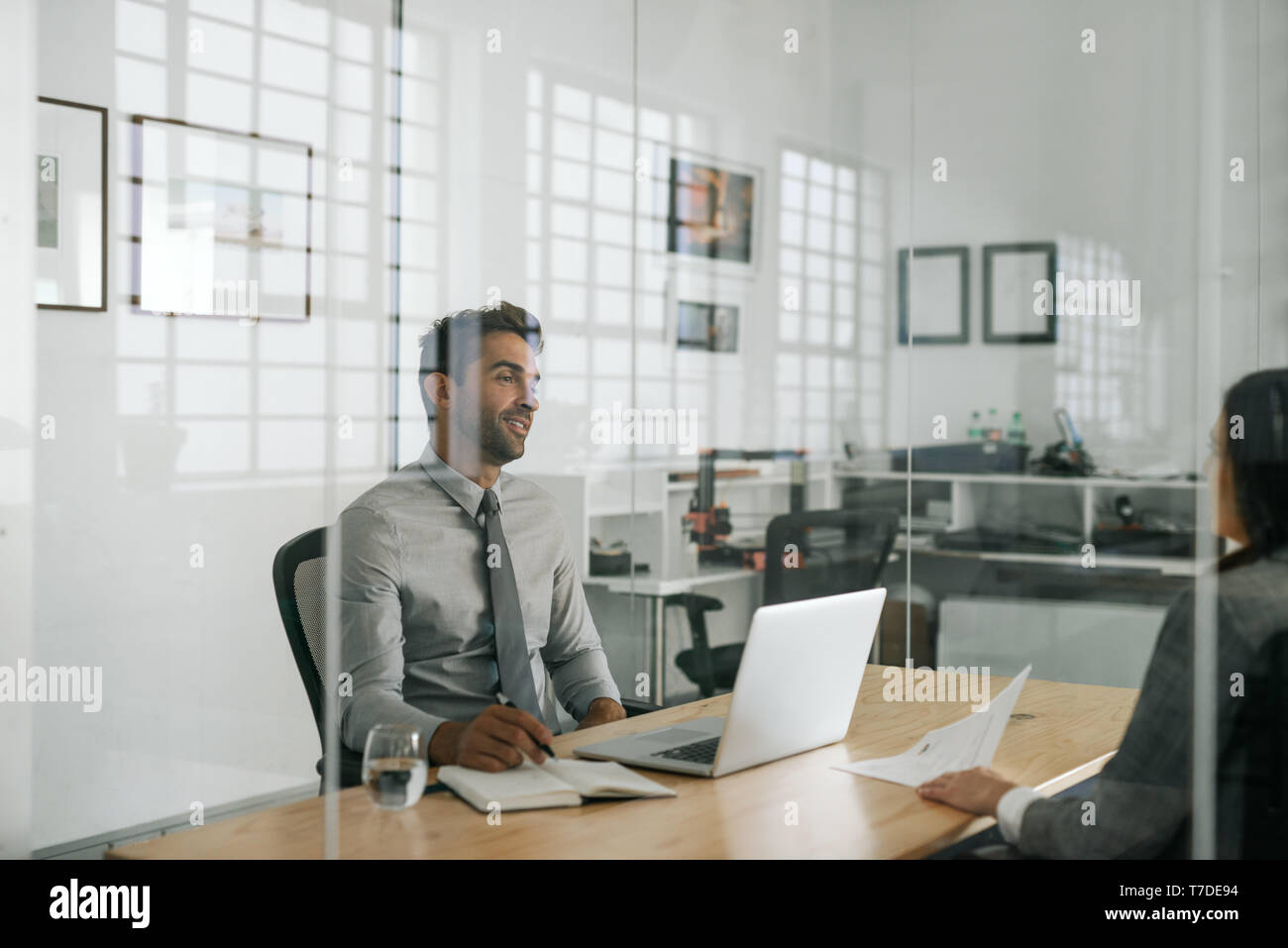 Sorridente manager parlando con un processo ricorrente nel suo ufficio Foto Stock