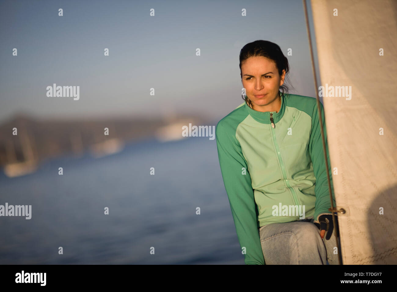 Mid-adulto donna seduta sulla prua di una barca a vela. Foto Stock