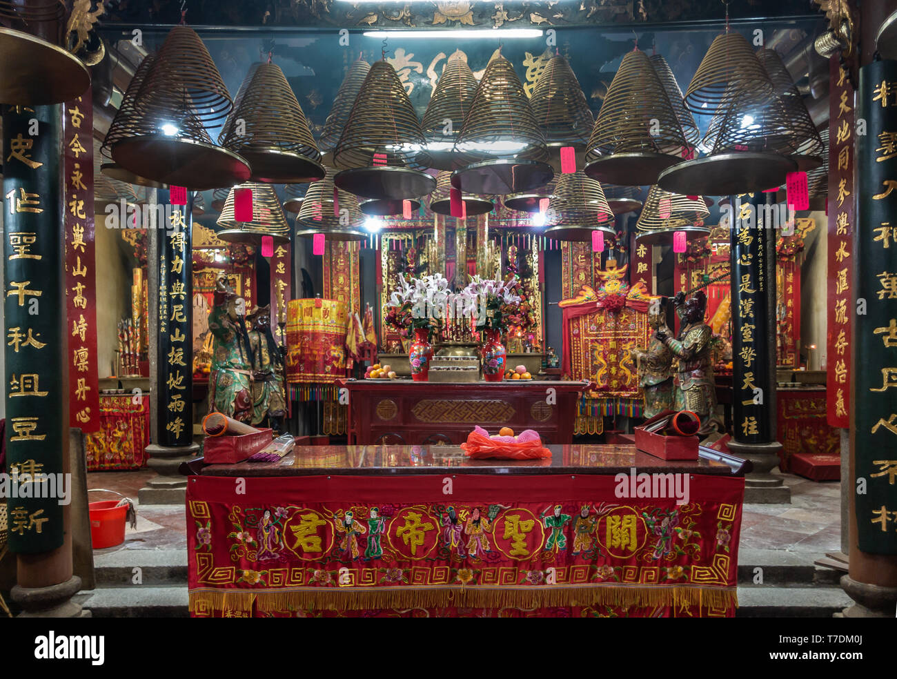 Hong Kong, Cina - 7 Marzo 2019: Tai O villaggio di pescatori. Sala principale di Kwan Tai tempio taoista con spirale incenso coni, luci, statue, altare, doni, Foto Stock