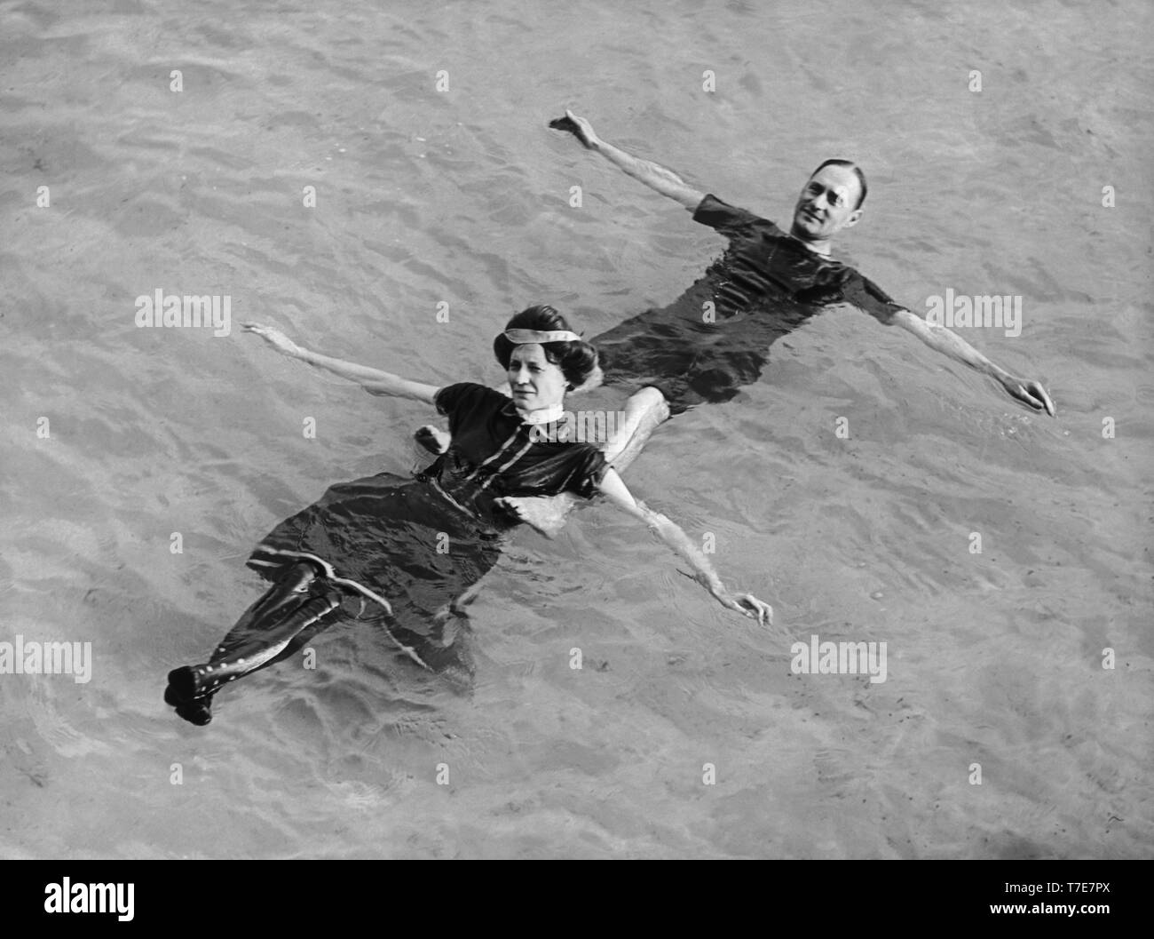 L uomo e la donna galleggiante sul loro dorso in acqua, Detroit Publishing Company, agli inizi del novecento Foto Stock