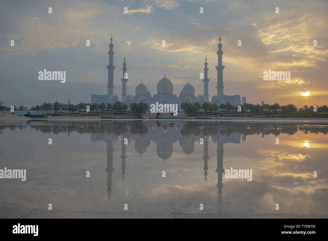 Vista assiale della Grande Moschea di Abu Dhabi al tramonto con la riflessione su uno specchio di acqua con nessuno, Regno emirato Arabo Foto Stock