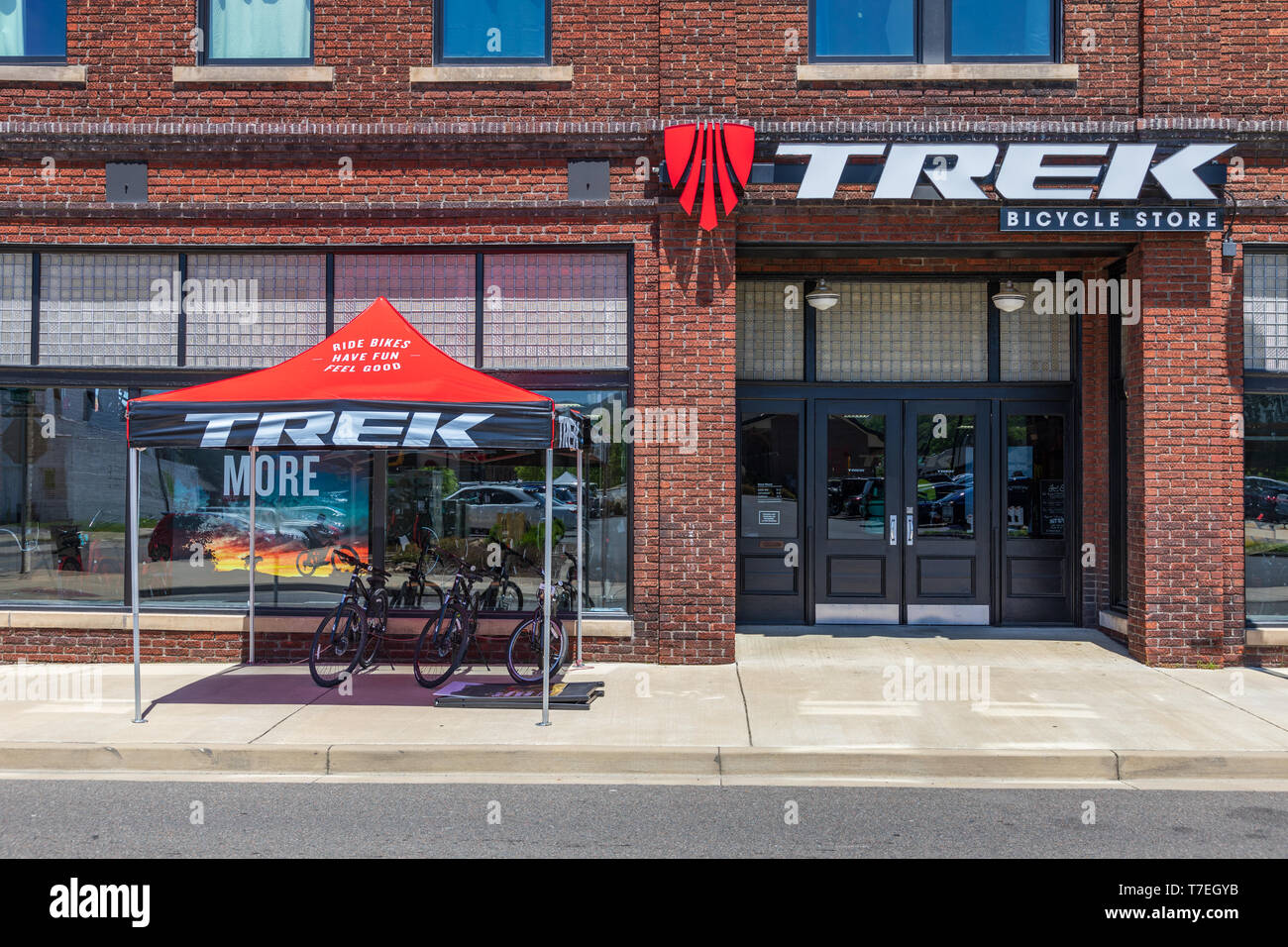 JOHNSON CITY, TN, Stati Uniti d'America-4/27/19: il Trek del negozio di biciclette, su W. Market Street nel centro cittadino, con una tenda rossa ombreggiatura moto sul marciapiede. Foto Stock