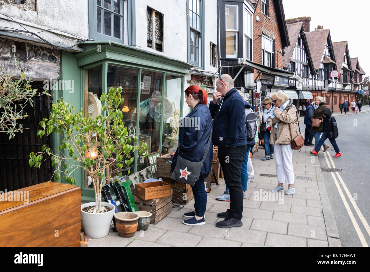 Una coppia di mezza età cercando nella finestra di un vintage negozio di antiquariato con pezzi di antiquariato che circonda la vetrina del negozio Foto Stock