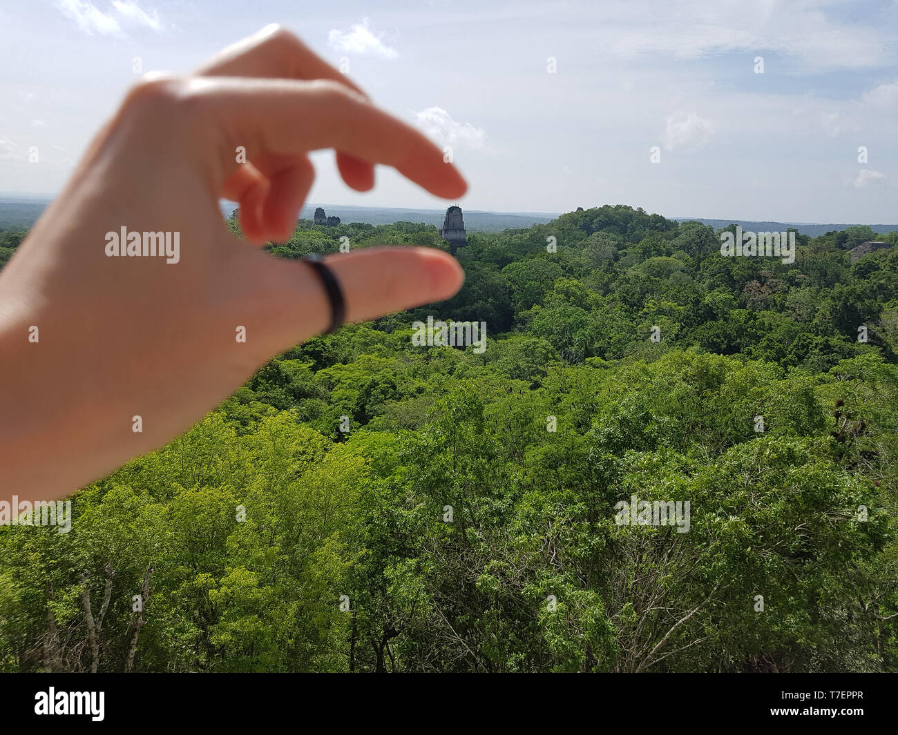 CLOSE-UP DI MANO fingendo di tenere TIKAL tempio con le dita Foto Stock