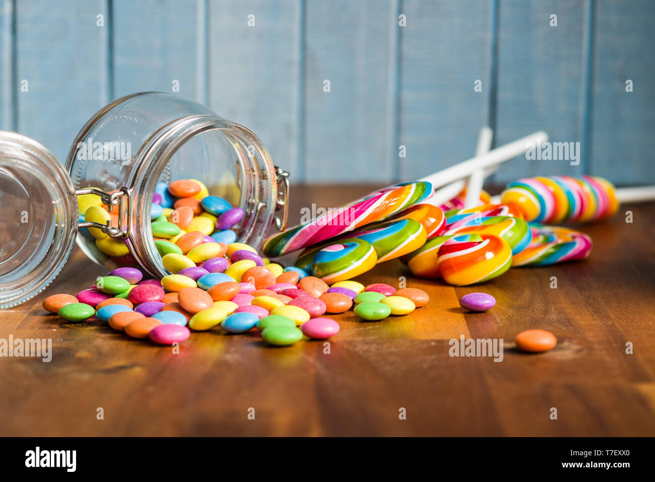 Swirl lecca lecca e caramelle colorate sul tavolo di legno. Foto Stock