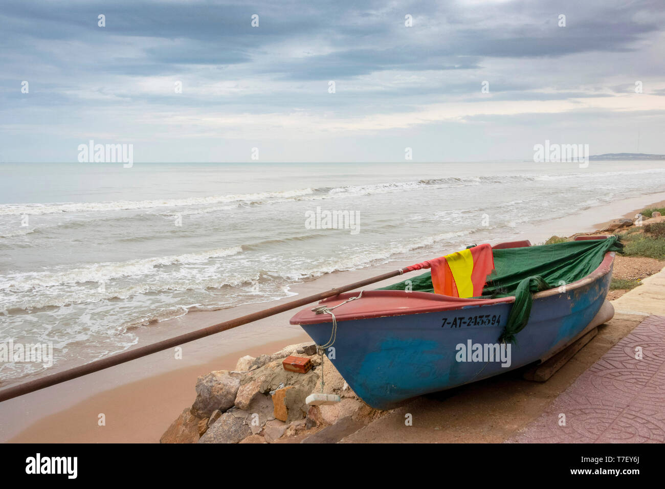 Piccola barca da pesca in un giorno di tempesta di una spiaggia deserta a El Pinet, vicino a Elche Alicante in Spagna Foto Stock