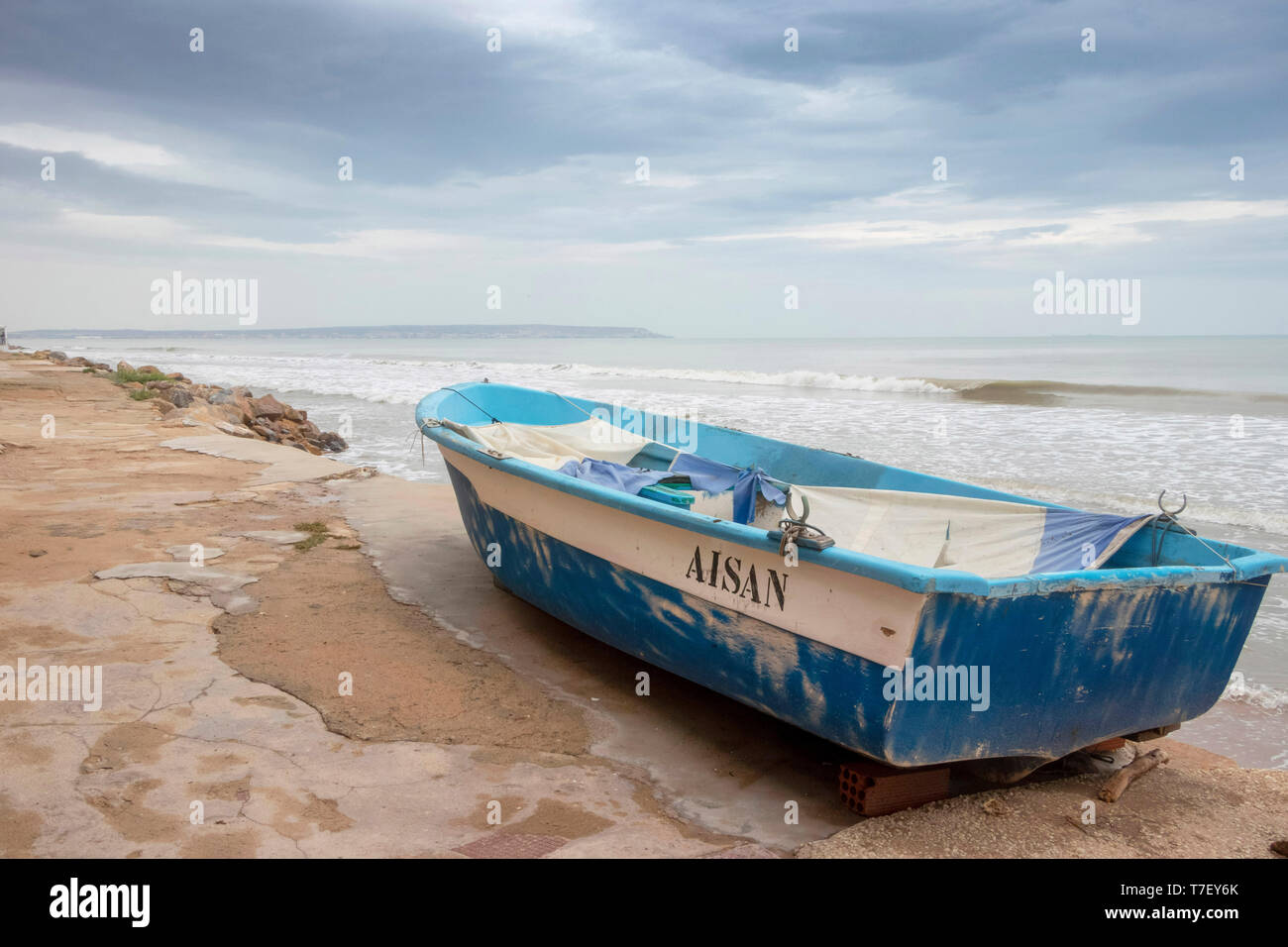 Piccola barca da pesca in un giorno di tempesta di una spiaggia deserta a El Pinet, vicino a Elche Alicante in Spagna Foto Stock