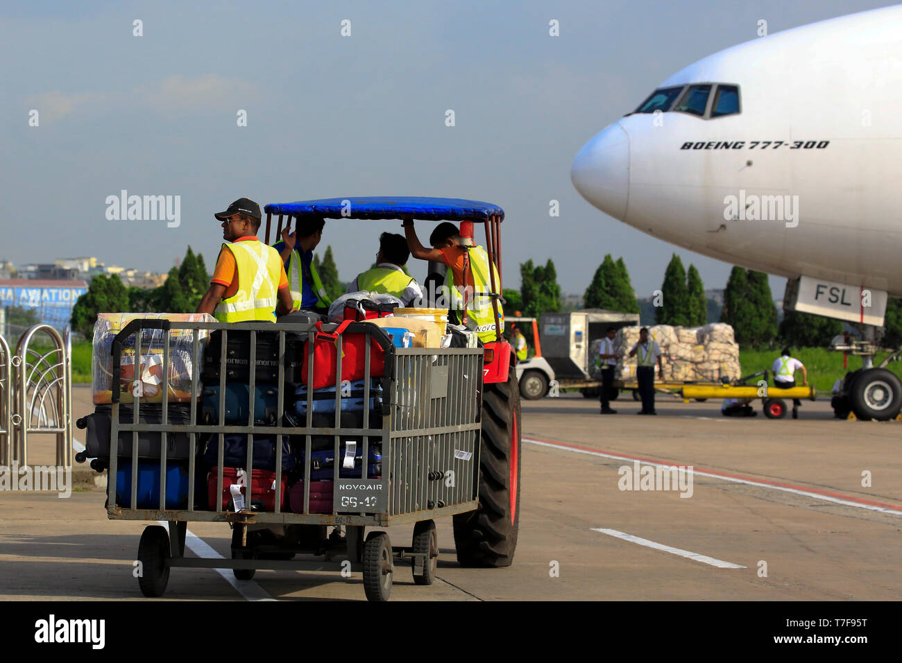 Gestore di bagaglio movimentazione bagagli in aeroporto airside Hazrat Shahjalal Hazrat Shahjalal International Airport a Dhaka, nel Bangladesh. Foto Stock