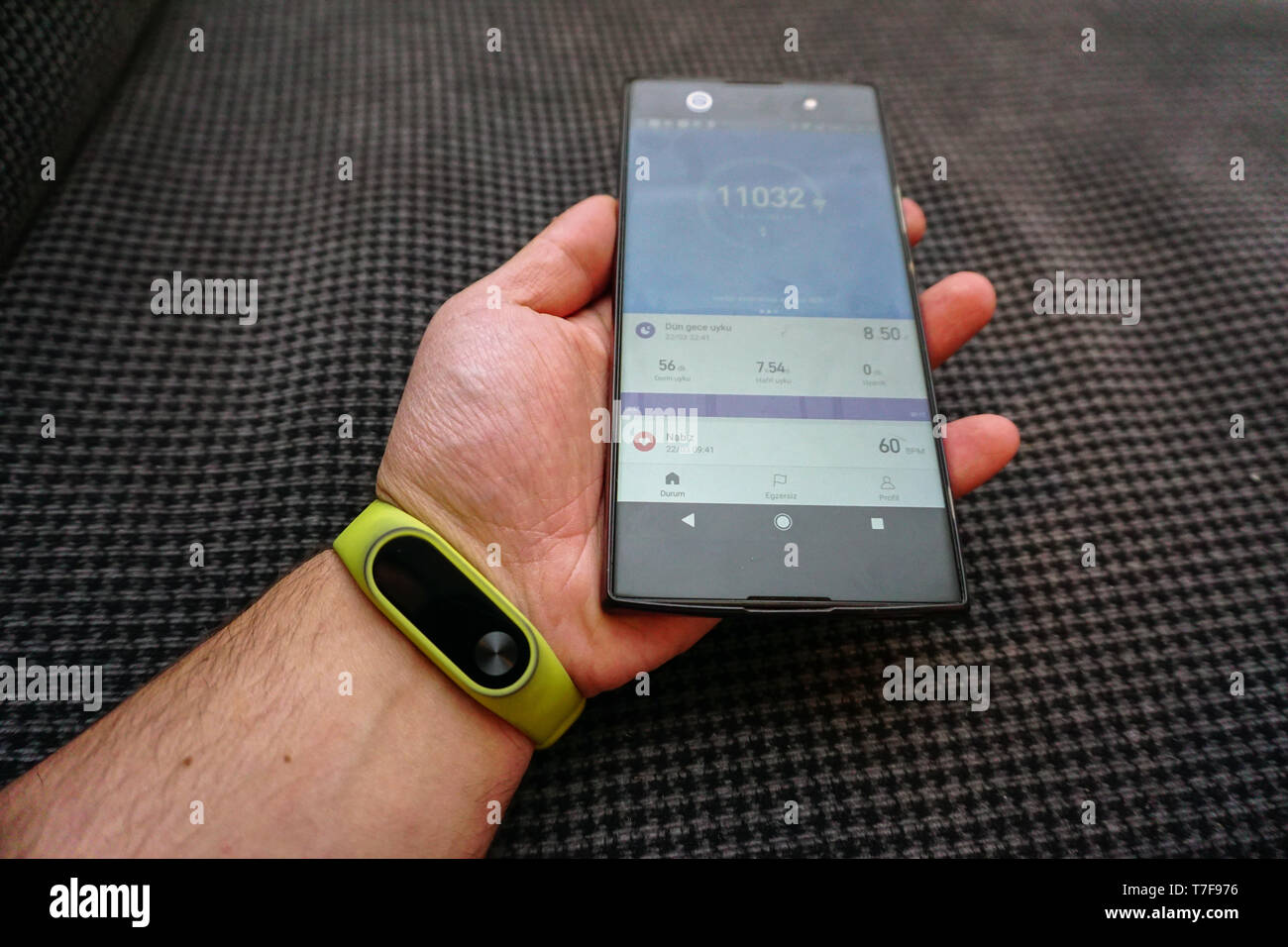 Smartphone e attività fitness tracker bracciale sul polso vista ravvicinata Foto Stock