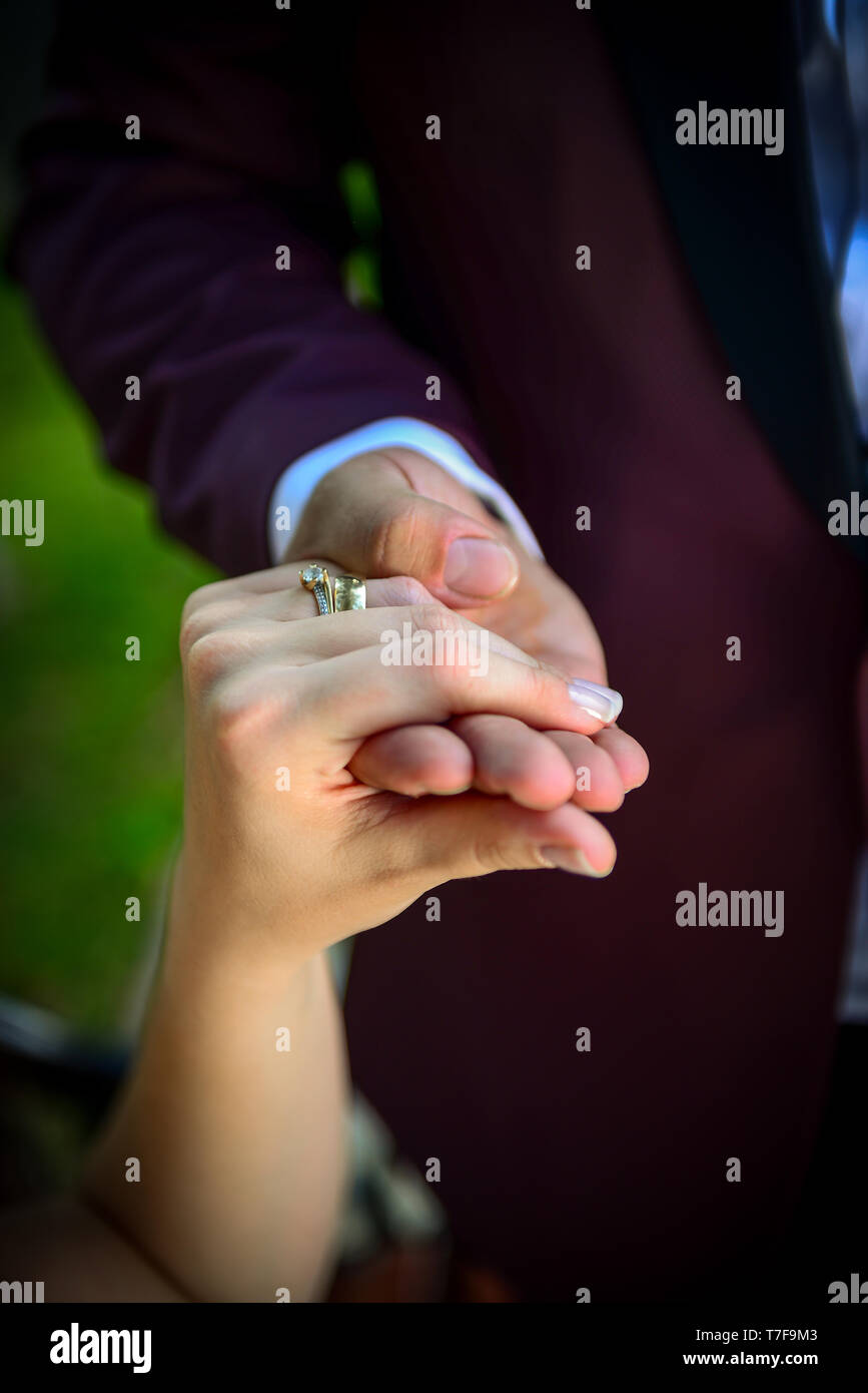 Sposa e lo sposo tenendo le mani con anelli di fidanzamento sulla loro dita vista ravvicinata di nozze concetto shoot Foto Stock