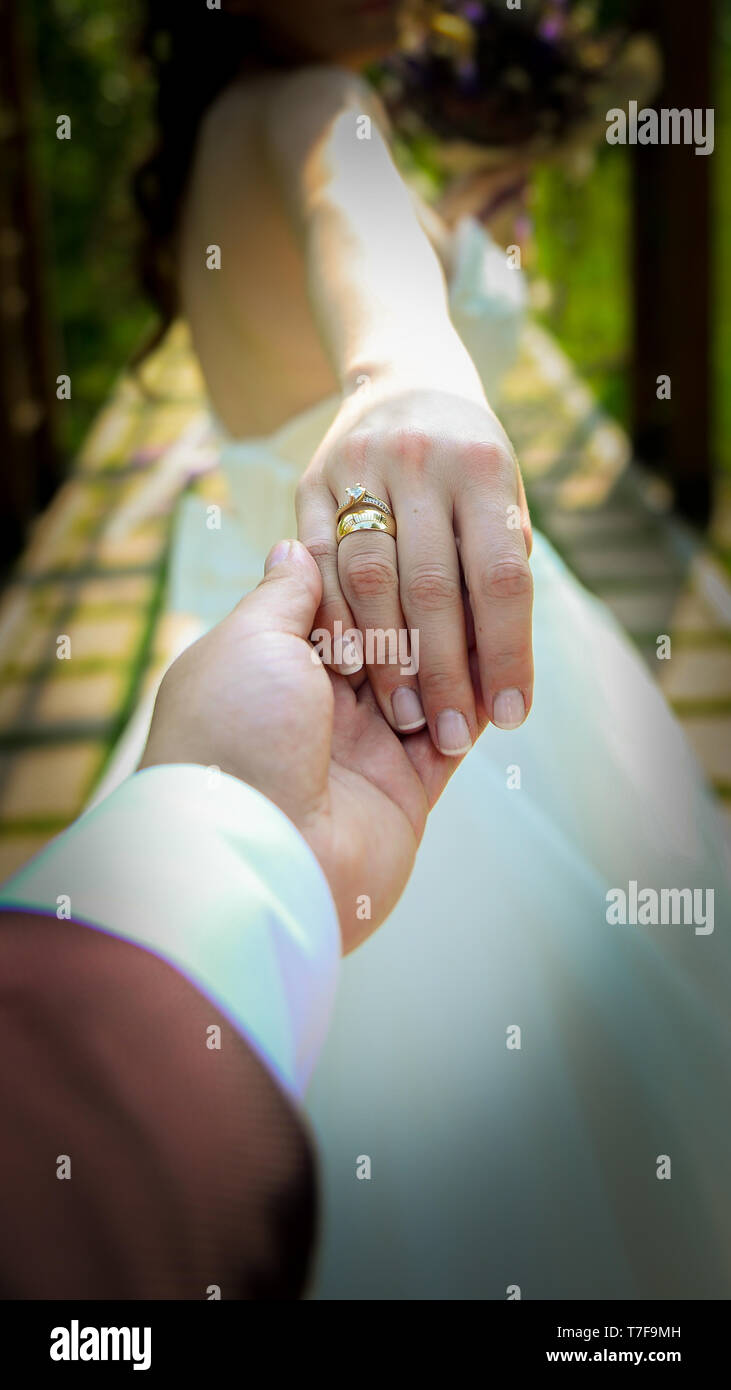 Sposa e lo sposo tenendo le mani con anelli di fidanzamento sulla loro dita vista ravvicinata di nozze concetto shoot Foto Stock