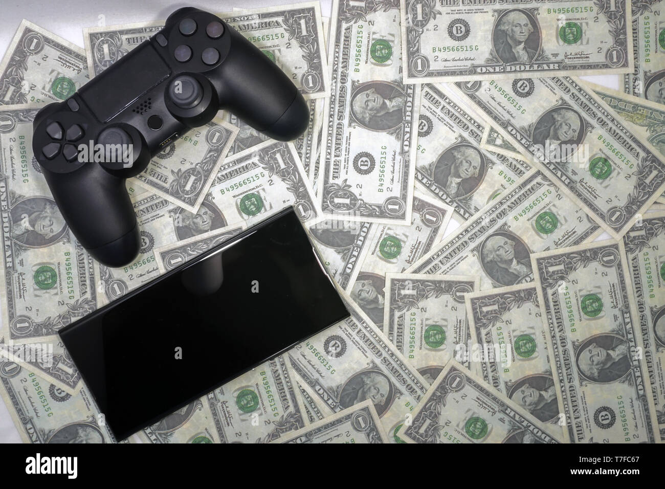 Gamepad smartphone e US dollar su sfondo isolato Foto Stock
