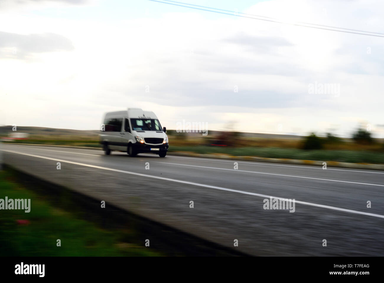 Minibus passando da con effetto di panning su strada Foto Stock