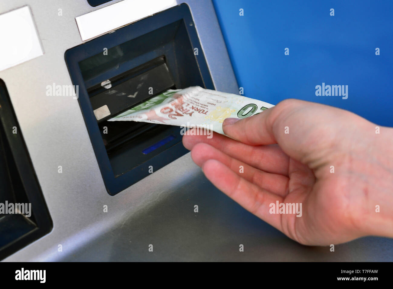 Inserendo la lira turca in chiosco con la mano vicino la vista Foto Stock