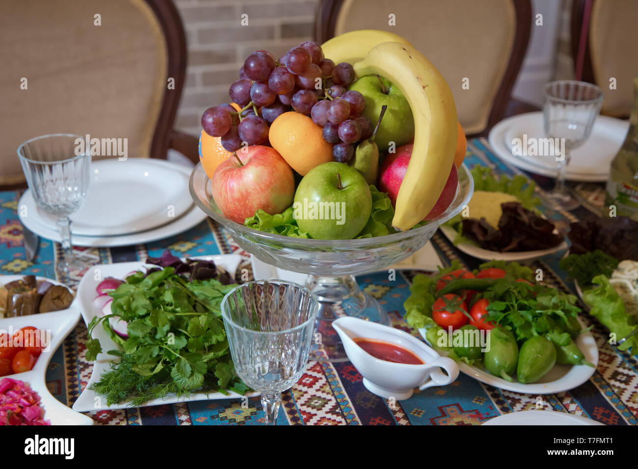 Il rosso e il blu di mela, arancio, rosso banana banana. Il cetriolo, pomodoro, verdi, Rafano. La frutta in una ciotola . Foto Stock