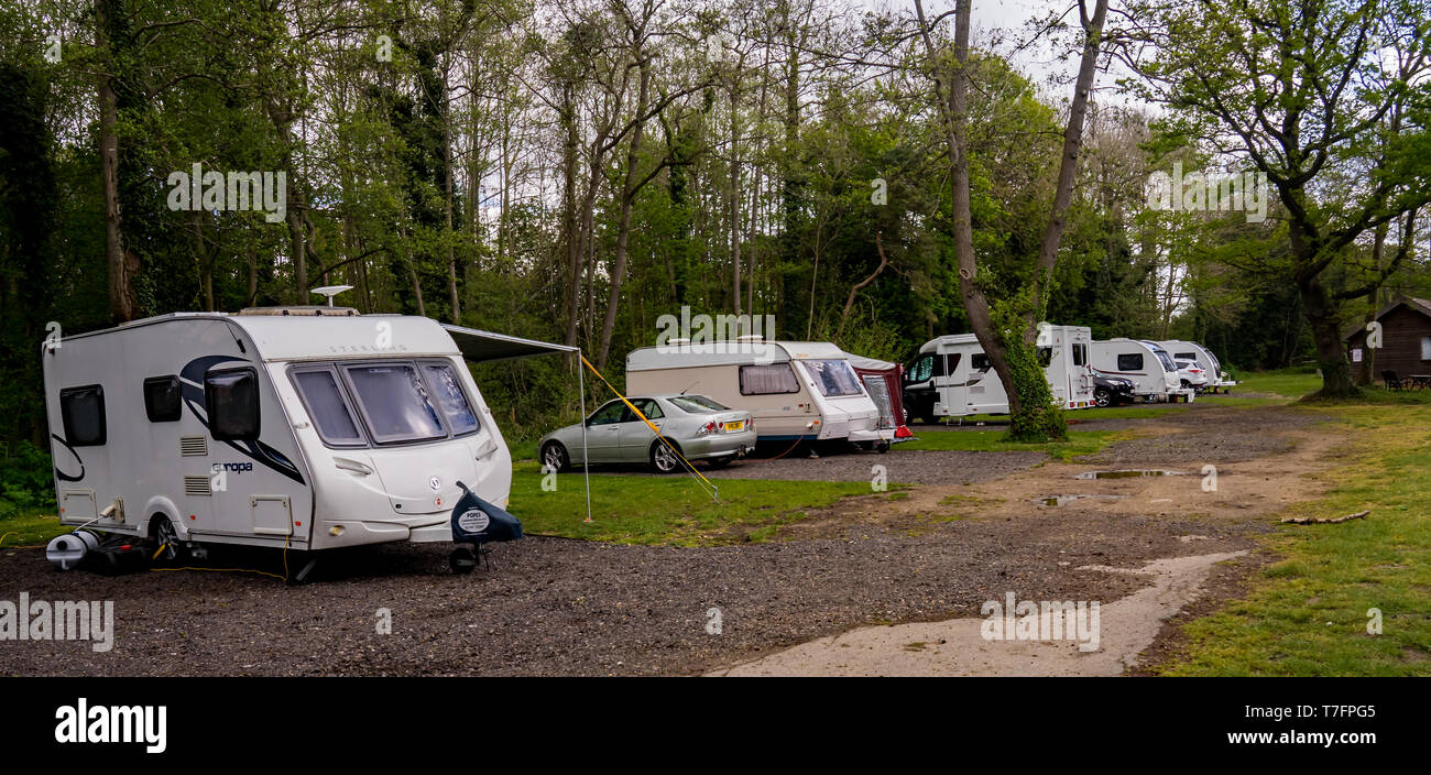 Le piccole unità di cinque touring campeggio nell' Est dell' Inghilterra al completo con quattro roulotte e camper. Foto Stock