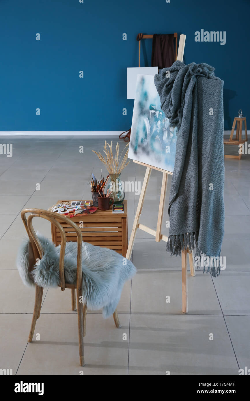 Cavalletto con una pittura astratta dell'artista e forniture in officina Foto Stock