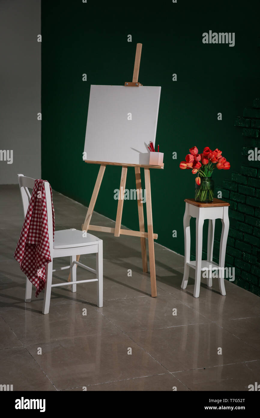 Cavalletto con tela e sedia in studio dell'artista Foto Stock
