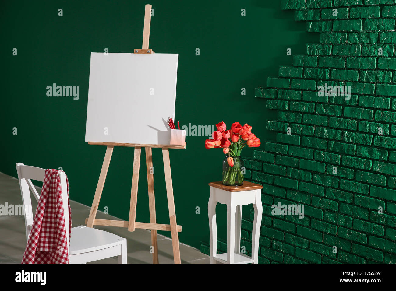 Cavalletto con tela e sedia in studio dell'artista Foto Stock