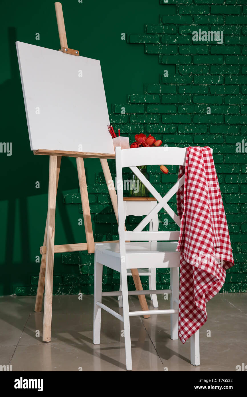 Cavalletto con tela e sedia in studio dell'artista Foto Stock