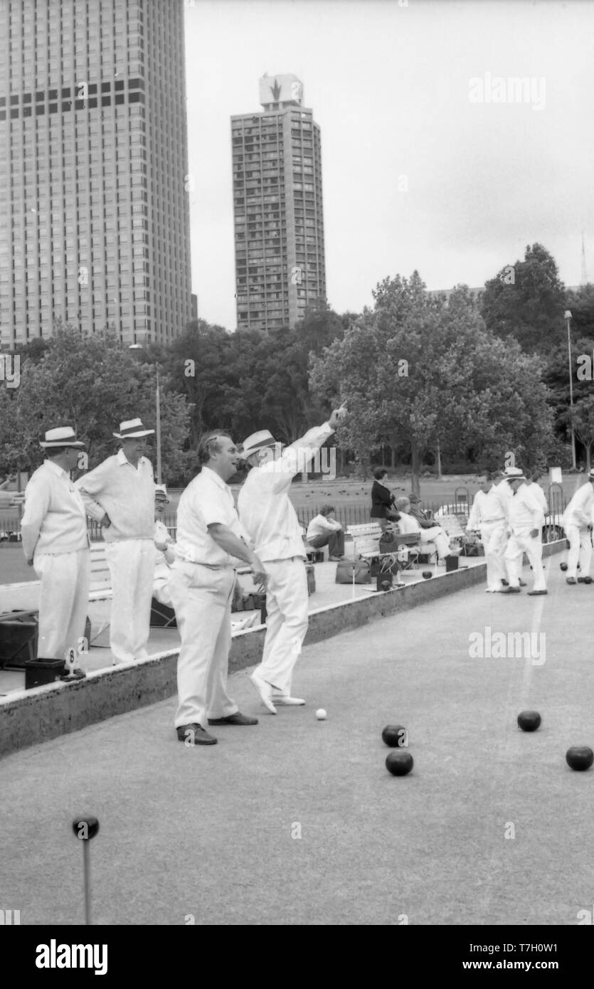 1977 Sydney, Australia: persone di mezza età e anziani uomini australiano lwan giocando a bocce presso l'ex bowling green su College Street. Il campo di bocce club è stato istituito nel 1880 e rimossa nel 1997 come parte di un importante rinnovamento della zona di fronte la Cattedrale di St Mary. Lo sfondo dell'immagine mostra gli alberi al confine con Hyde Park e una notevole mancanza di un grattacielo che esistono oggi. Il solo due sono visibili sono il Park Regis Hotel (incoronato) e la torre di uffici in 201 Elizabeth Street Foto Stock