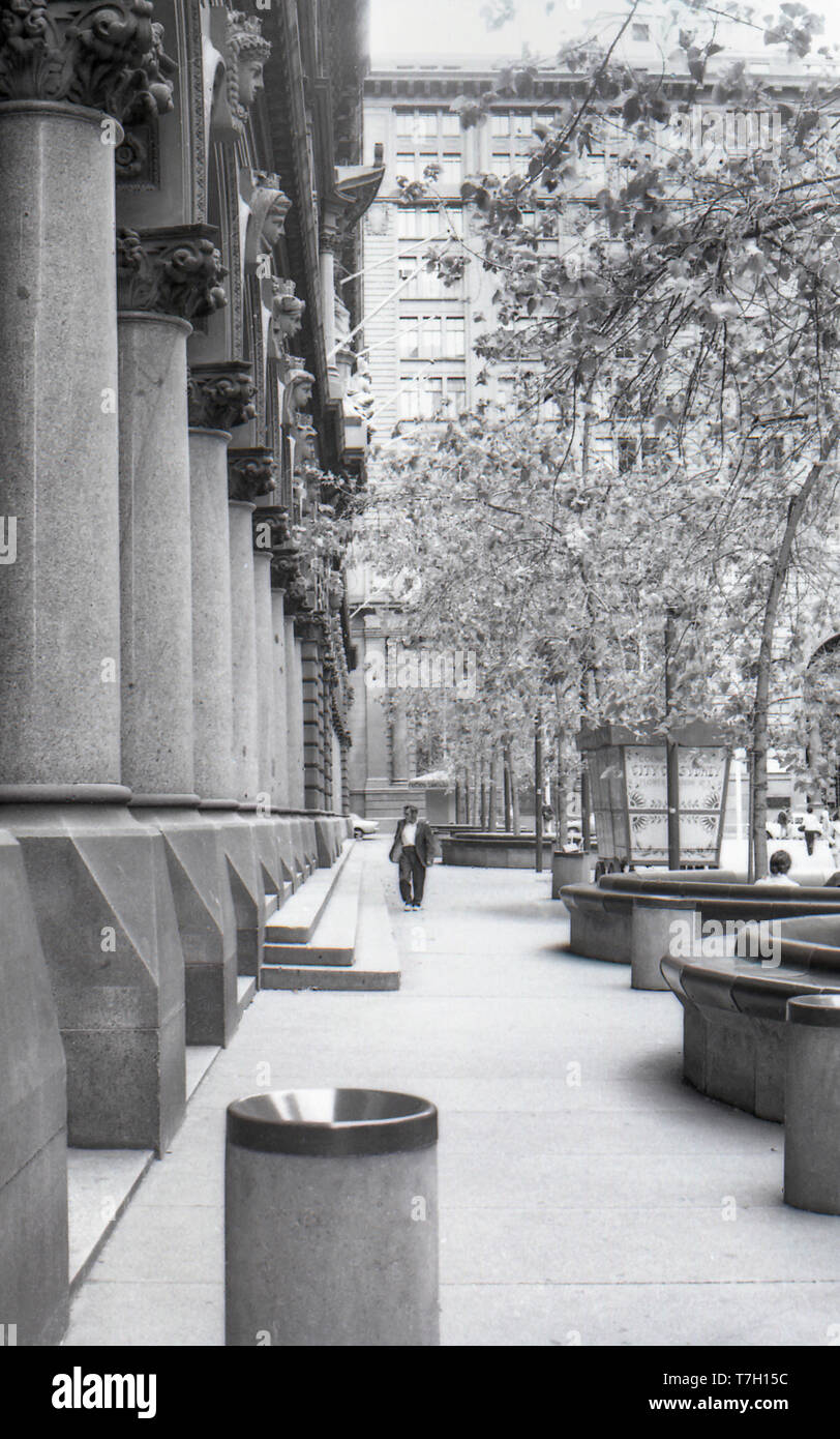 1977 Martin Place, Sydney Australia: un poco vestite persona, eventualmente un vagabondo o persona senzatetto passeggiate lungo la parte anteriore del GPO (General Post Office). Intorno a questo tempo era comune per i senzatetto a dormire su i portali del post office, lontano da pioggia e vento. Foto Stock