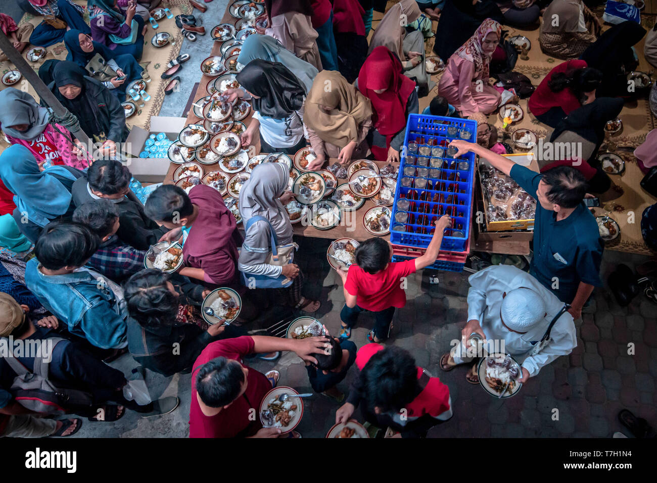 Musulmani indonesiani vede riuniti per iftar (fast-breaking) cena durante il mese sacro del Ramadan alla Moschea Jogokariyan in Yogyakarta, Indonesia. I musulmani di tutto il mondo celebrano il mese sacro del Ramadan pregando durante la notte e di astenersi dal mangiare e dal bere durante il periodo compreso tra gli orari di alba e tramonto. Foto Stock