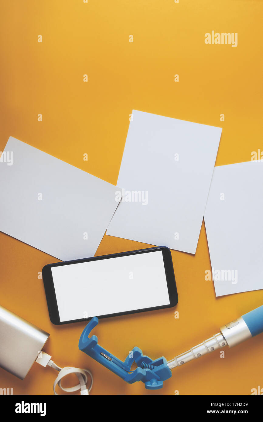 Piatto monopiede laici con uno smartphone e foto su uno sfondo giallo. Estate concetto di viaggio Foto Stock