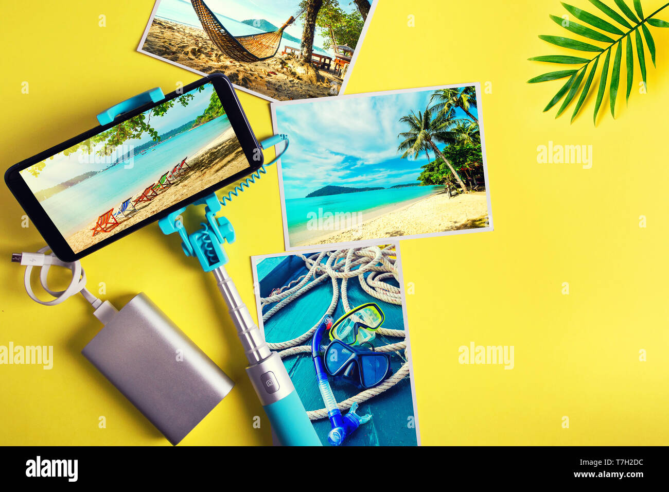 Piatto monopiede laici con uno smartphone e foto su uno sfondo giallo. Estate concetto di viaggio Foto Stock