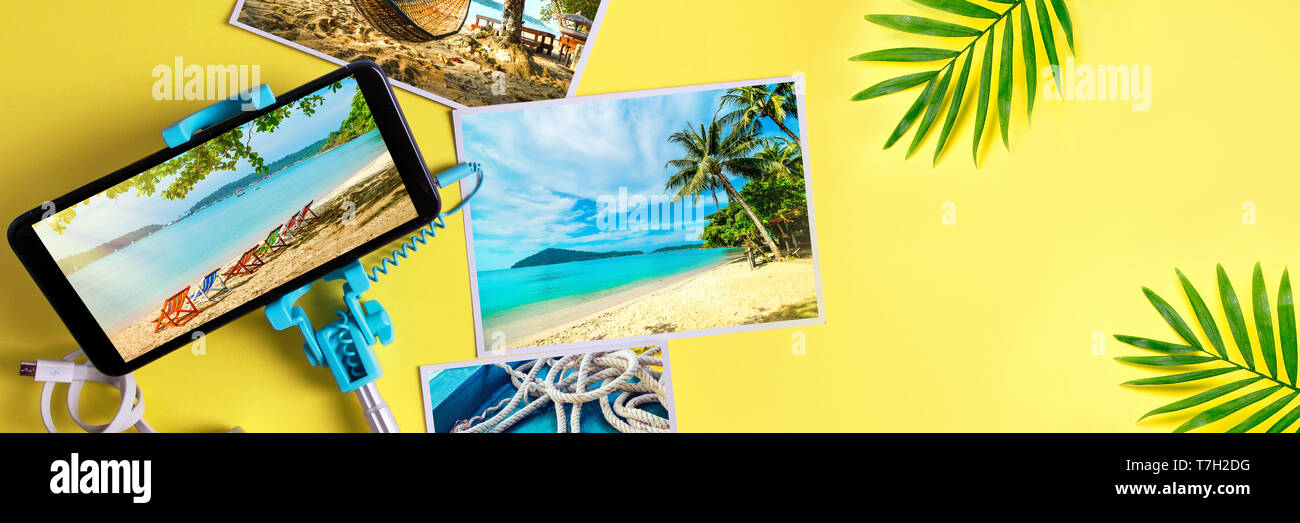 Piatto monopiede laici con uno smartphone e foto su uno sfondo giallo concetto di viaggio Banner Foto Stock
