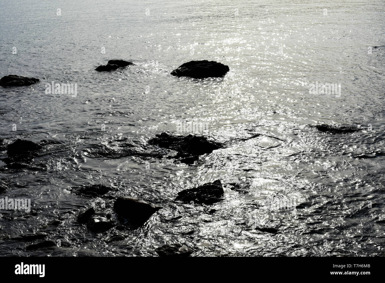 Rocce nere nell'oceano Foto Stock