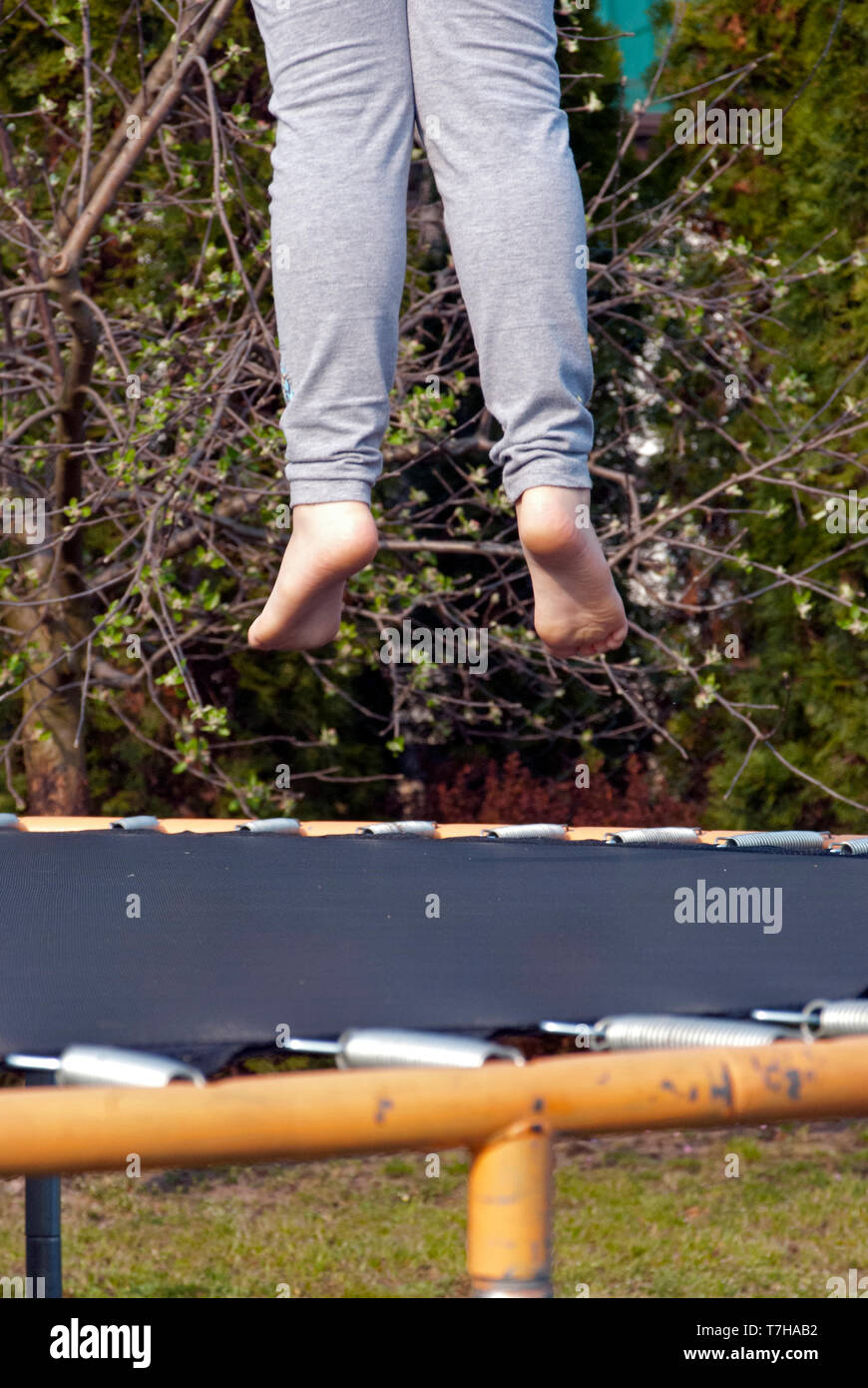 Piedi sopra il trampolino, saltando sul trampolino in giardino Foto Stock