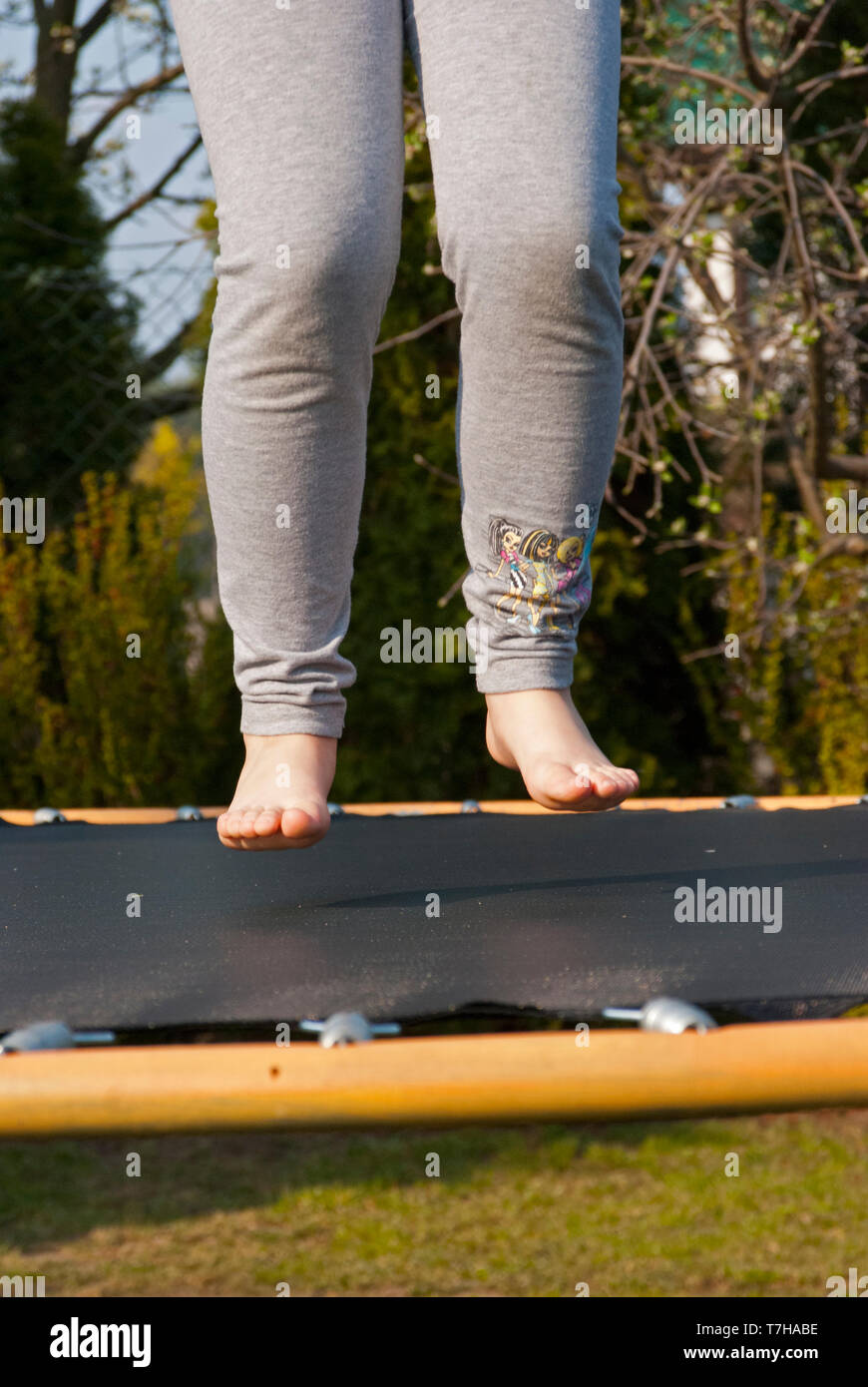 Le gambe sopra il trampolino, saltando sul trampolino in giardino Foto Stock