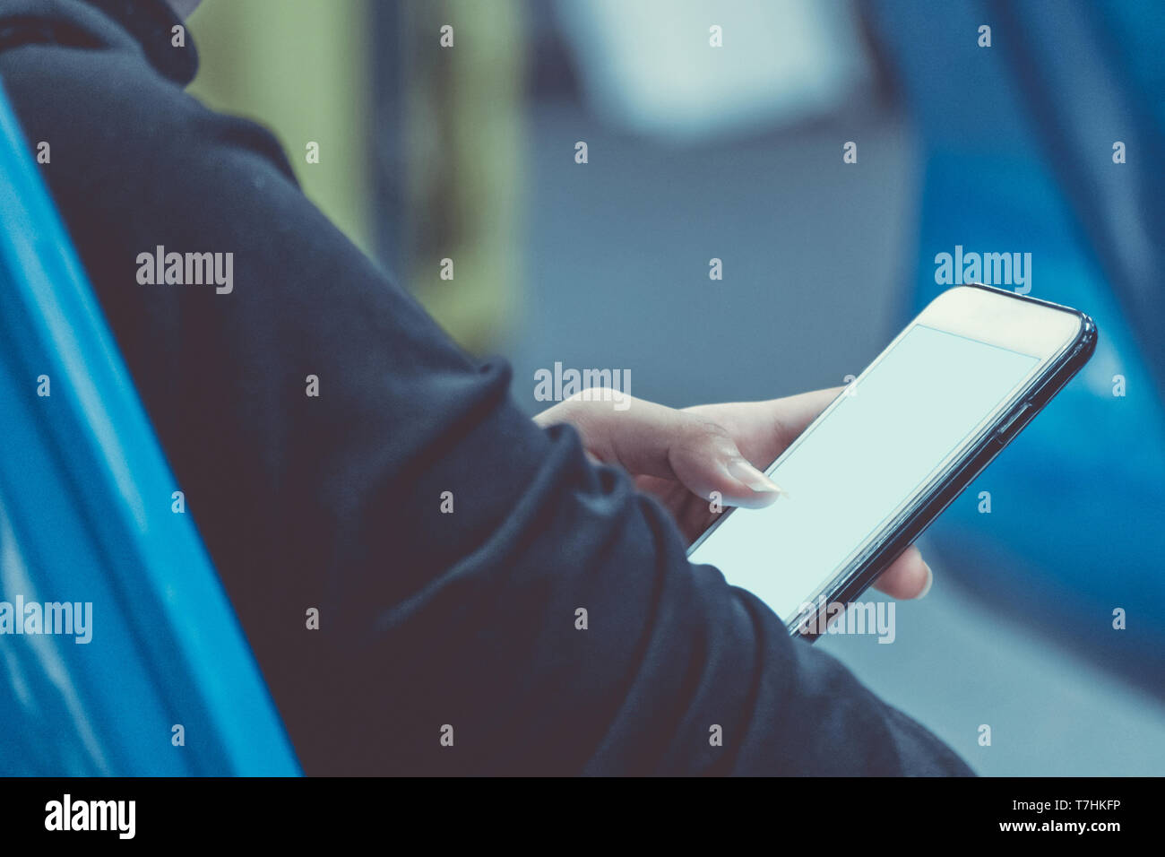 Donna che mantiene e utilizzando lo smartphone mobile per collegare airport wifi internet alla ricerca di informazioni mentre si è in attesa del volo all'aeroporto termin Foto Stock