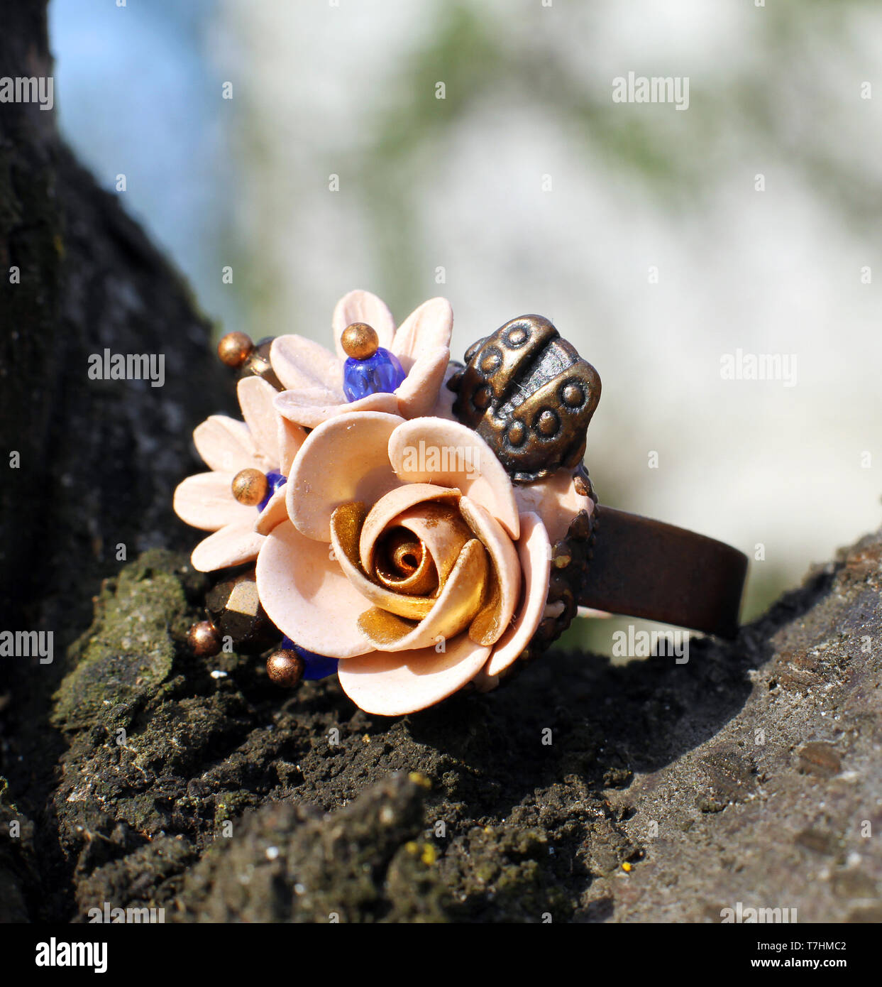 Il fatto a mano anello in una forma di fiori da polymer clay su sfondo di legno Foto Stock