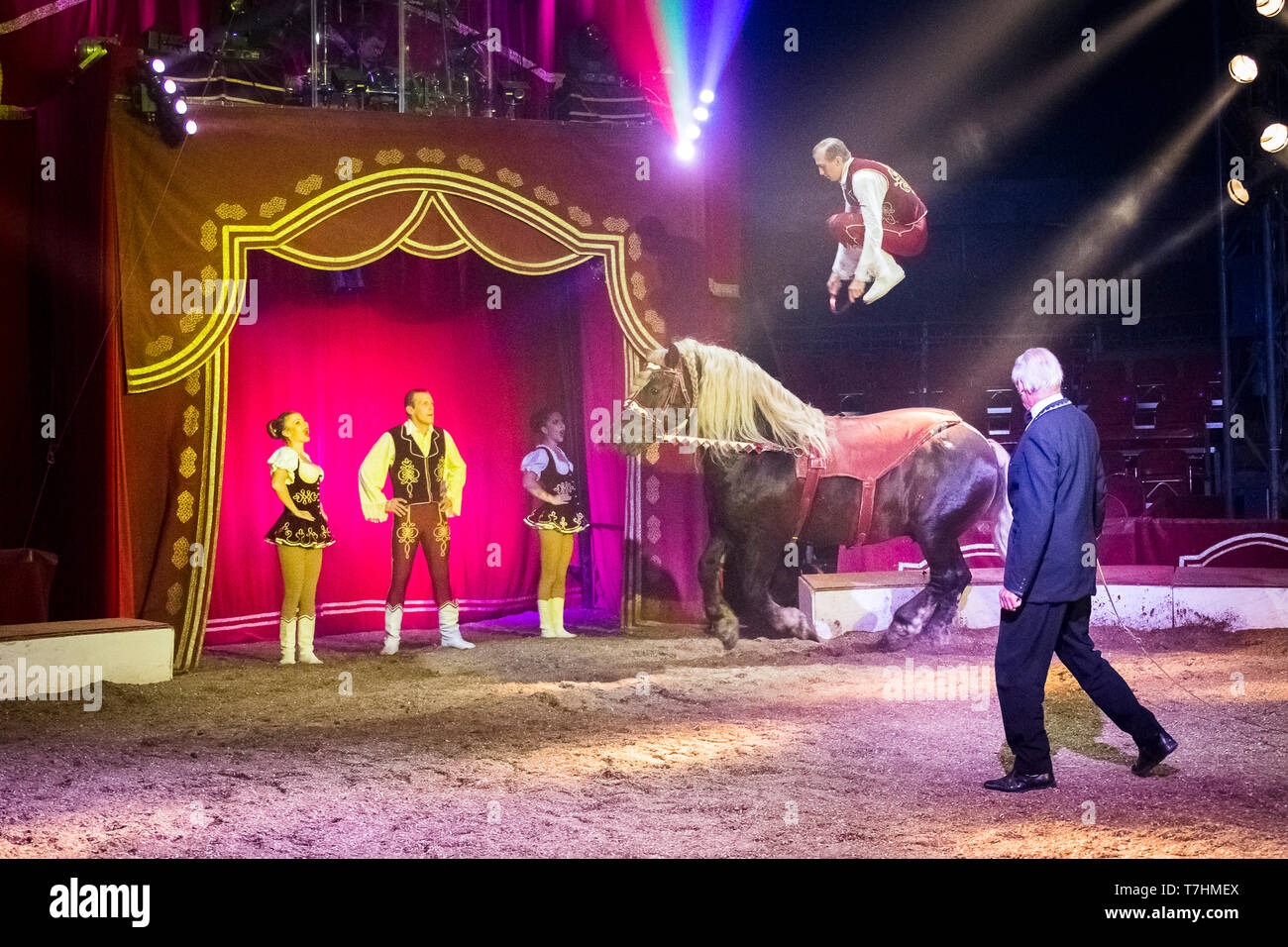 Attore di saltare sul retro di un pesante russo progetto cavallo durante una mostra presso il circo Louis Knie junior, Austria Foto Stock