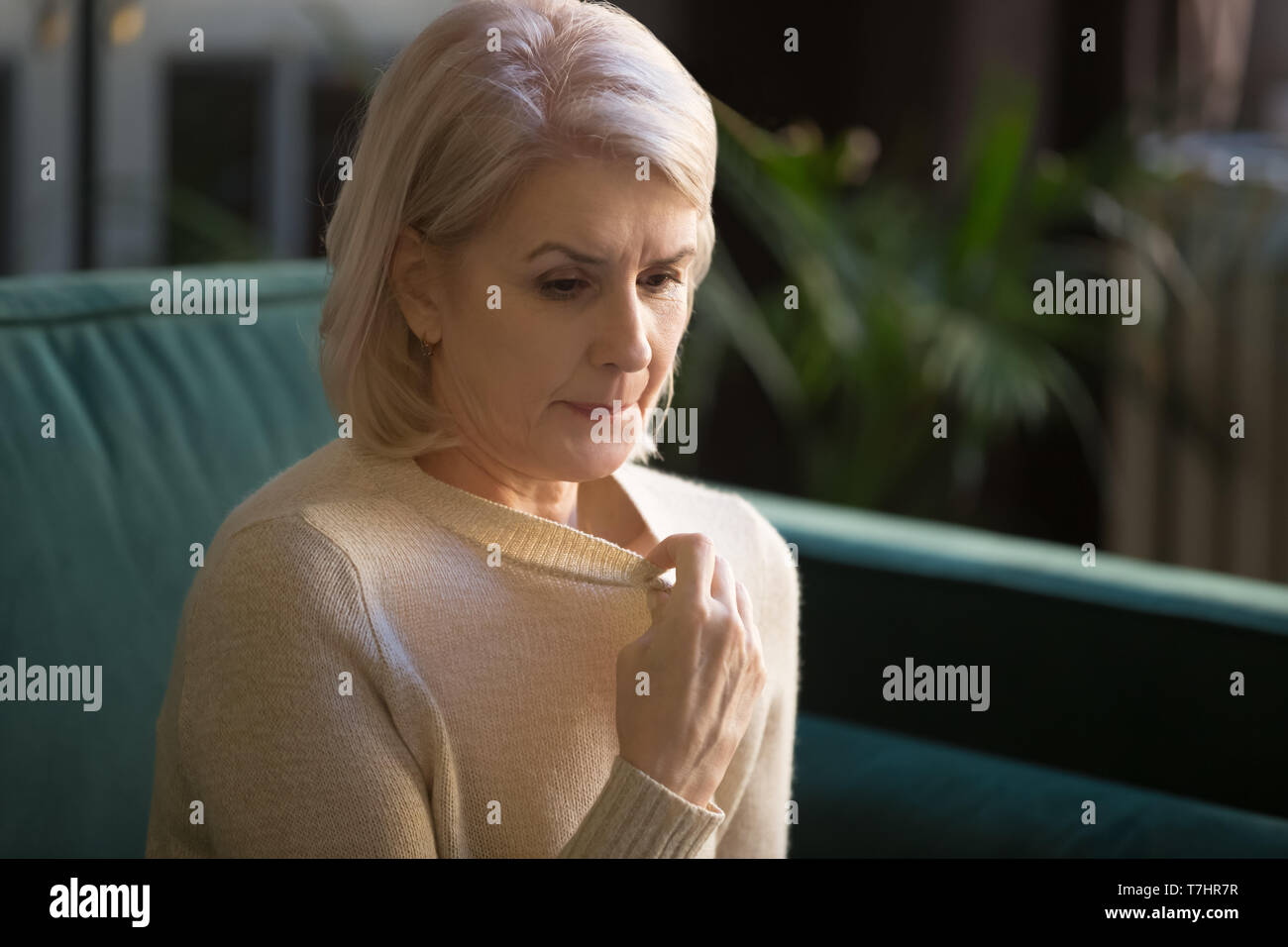 Capelli grigi donna matura nella sofferenza maglione da alta temperatura Foto Stock