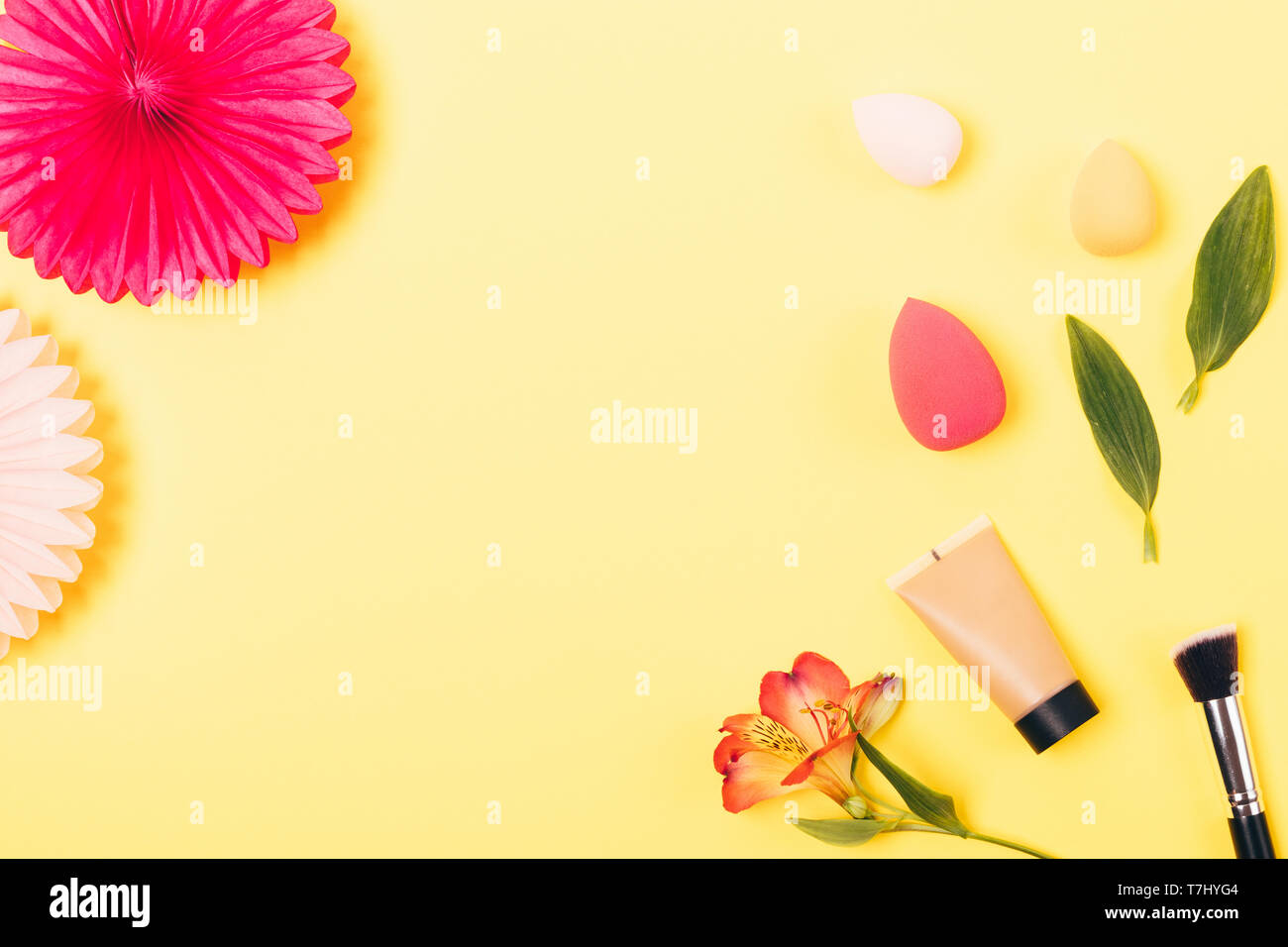 Cosmetica decorativa per anche incarnato e accessori per l'applicazione: trucco pennello e miscelazione di spugne, piatto laici sul telaio di colore giallo brillante backgroun Foto Stock